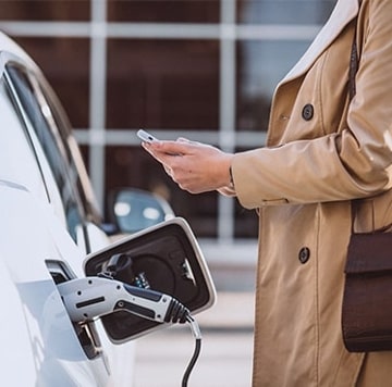 Mujer revisando el teléfono junto a EV