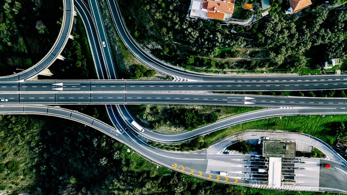 Aerial view of a busy highway and expressway interchange with vehicles traveling in multiple lanes. Aerial view of a busy highway and expressway interchange with vehicles traveling in multiple lanes.
