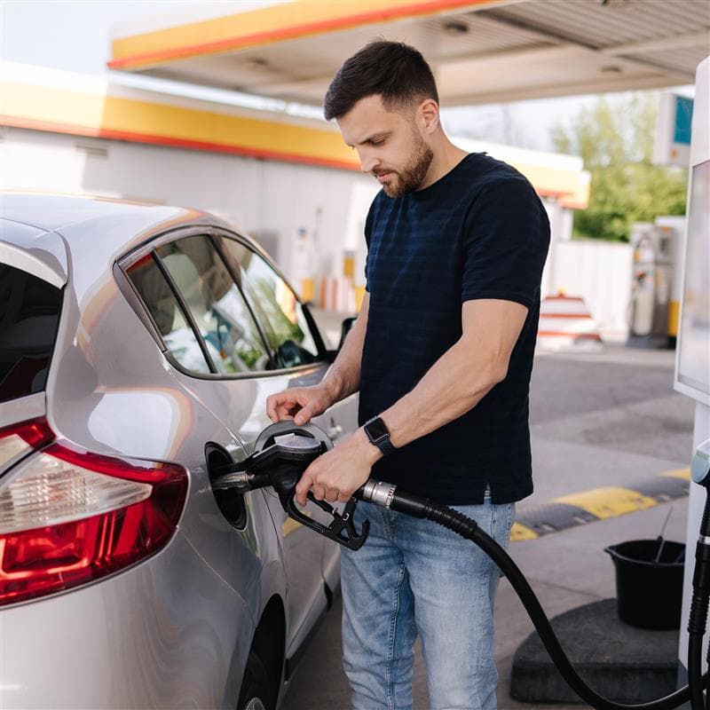 Hombre recargando gasolina en un vehículo Hombre recargando gasolina en un vehículo