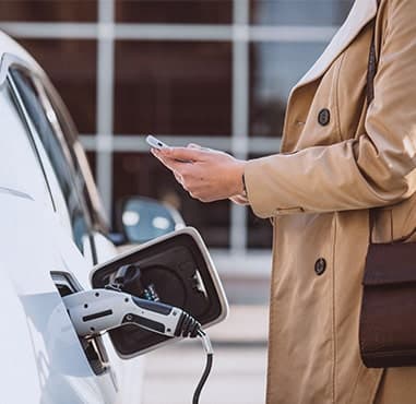 solutions-callout-woman-next-to-ev-min solutions-callout-woman-next-to-ev-min
