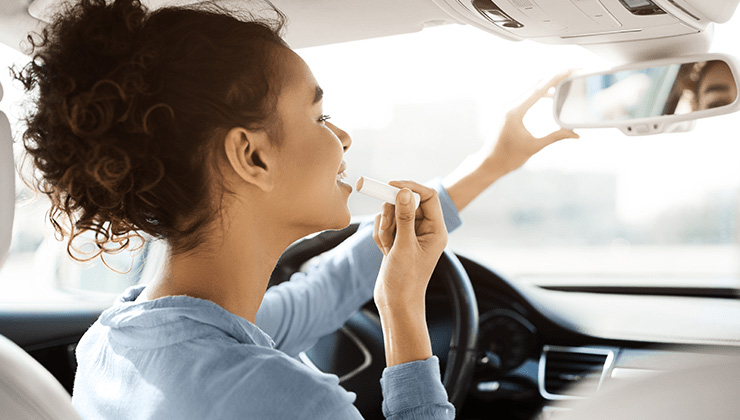 mujer al volante maquillándose